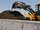 A wheel loader is dumping compost onto a pile