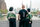 Three people are standing on a bridge over a river